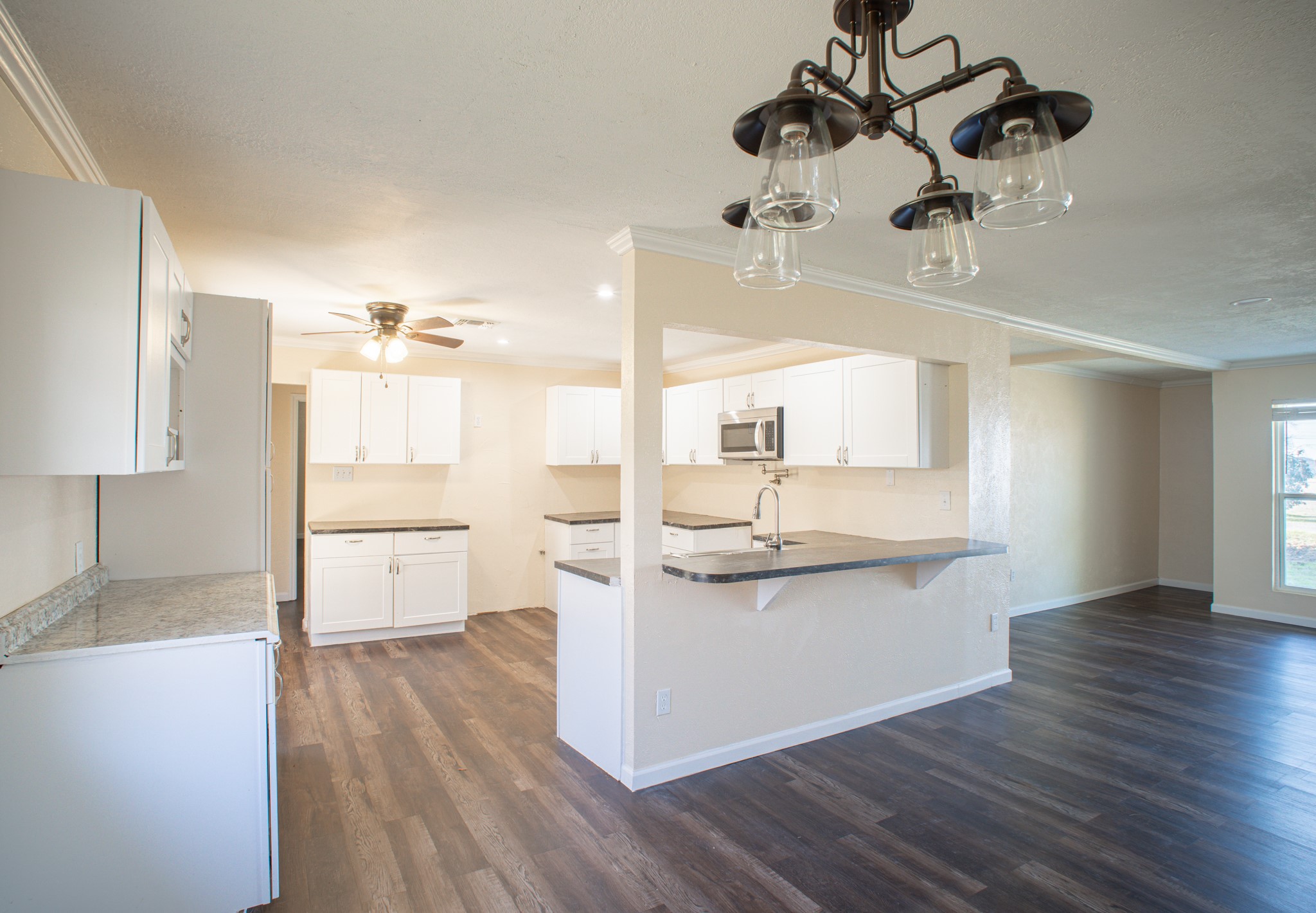 214 North Calhoun Street Groesbeck, TX 76642 - Photo 10 of 20 a kitchen with a refrigerator a sink and wooden floor