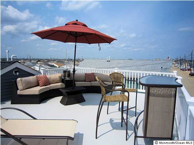 3305 Seaview Road Lavallette, NJ 08735 - Photo 1 of 13 a view of a tables and chairs under an umbrella