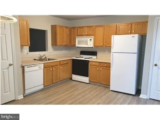 a kitchen with a sink refrigerator and cabinets
