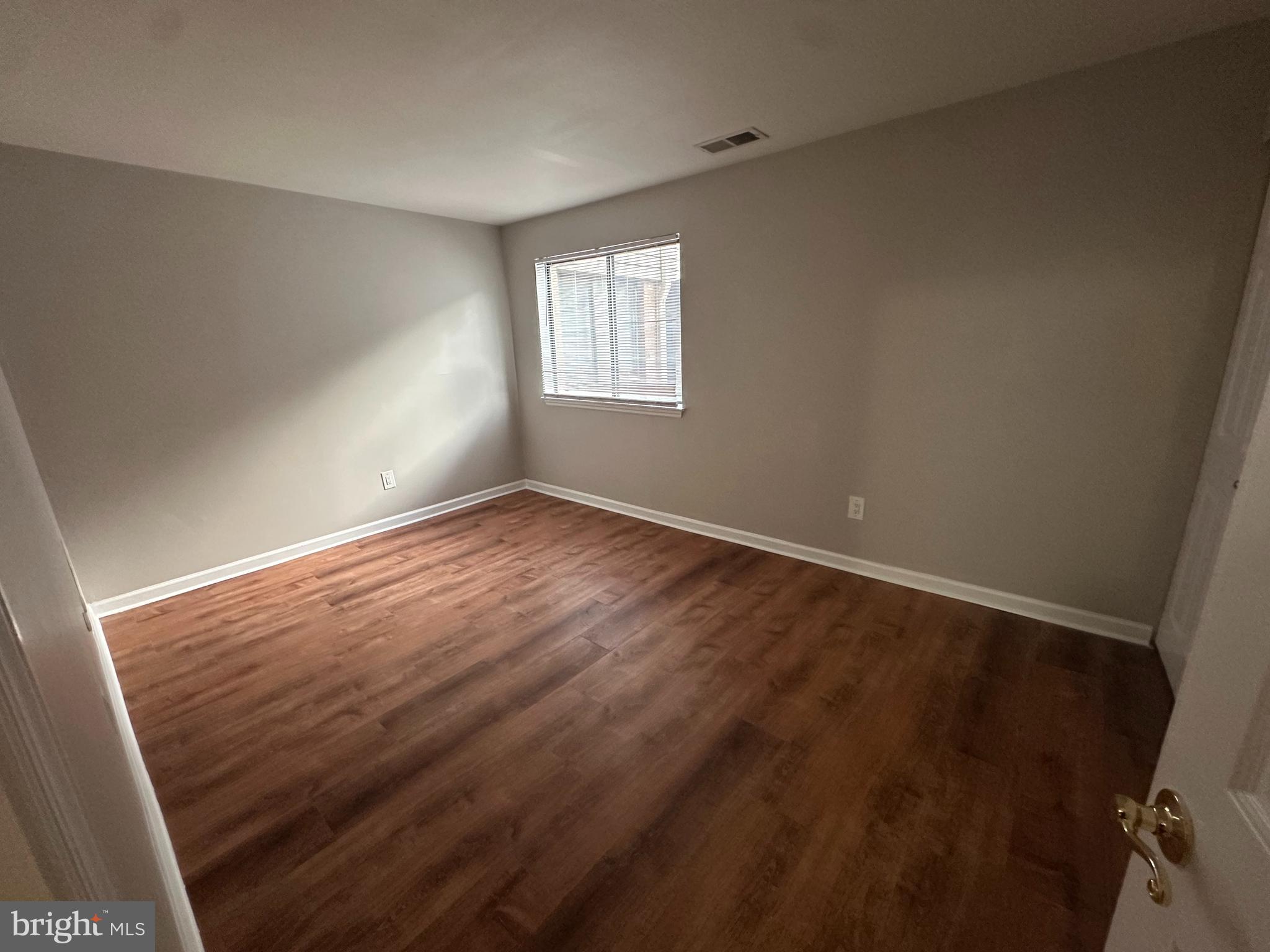 1801 Egg Harbor Road, Unit 105 Clementon, NJ 08021 - Photo 12 of 14 an empty room with wooden floor and windows