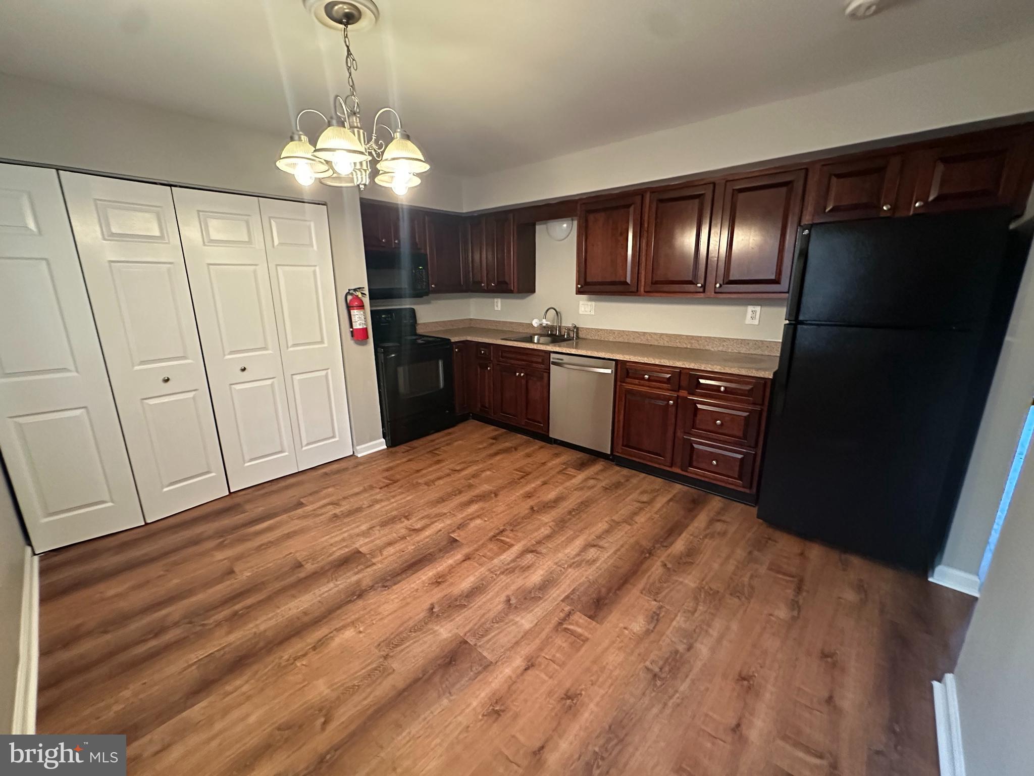 1801 Egg Harbor Road, Unit 105 Clementon, NJ 08021 - Photo 4 of 14 a large kitchen with granite countertop a refrigerator and a wooden floor