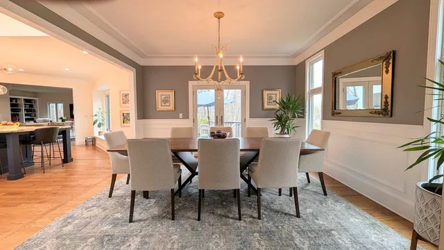 a view of a a dining room with furniture window and wooden floor