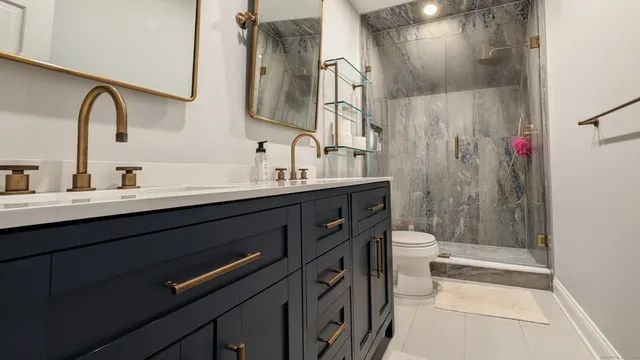 a bathroom with a double vanity sink toilet and shower