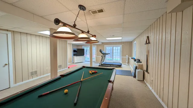a room with lots of wooden furniture and windows