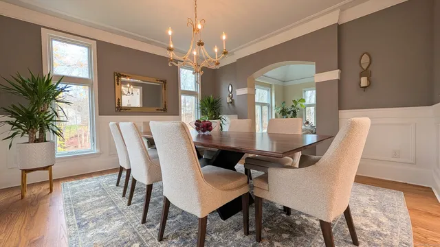 a view of a dining room with furniture a chandelier and wooden floor