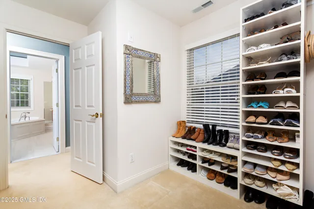 a view of walk in closet with clothes and shoes