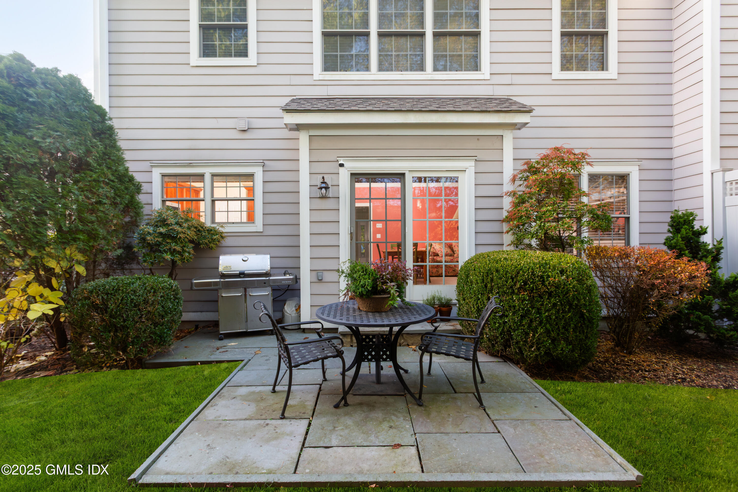 105 Hamilton Avenue, Unit 9 Greenwich, CT 06830 - Photo 16 of 20 a view of a house with a backyard and a table and chair