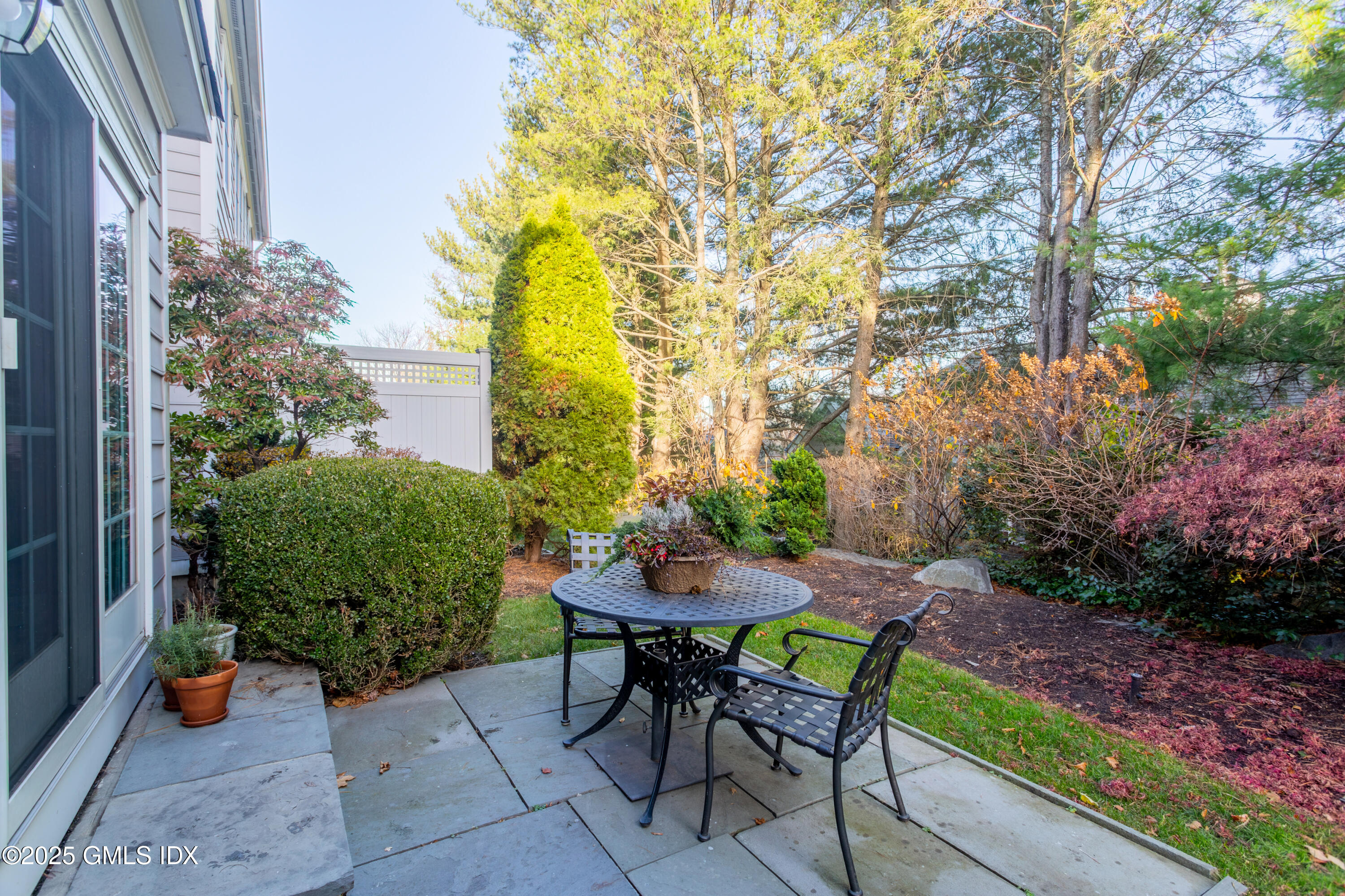 105 Hamilton Avenue, Unit 9 Greenwich, CT 06830 - Photo 17 of 20 a backyard with table and chairs and potted plants