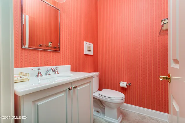 a bathroom with a sink a toilet and mirror
