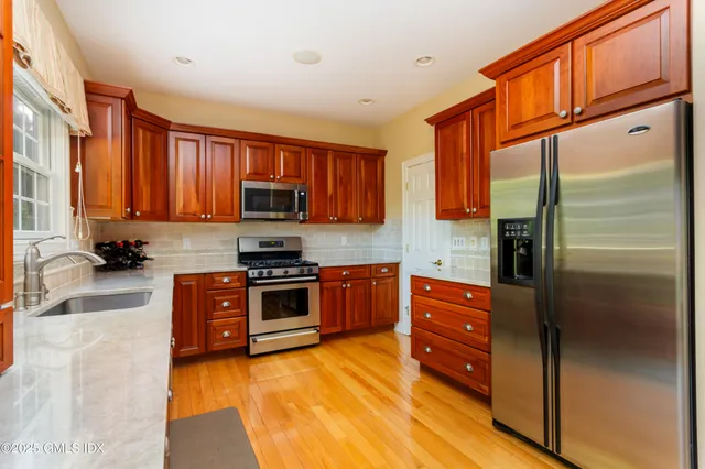a kitchen with stainless steel appliances granite countertop a refrigerator and a stove top oven