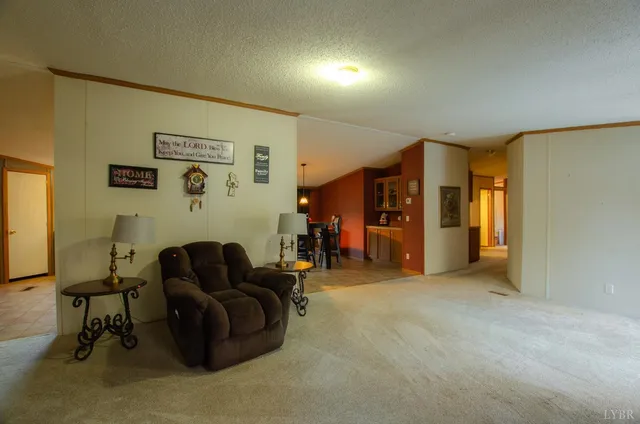 a living room with furniture and a refrigerator