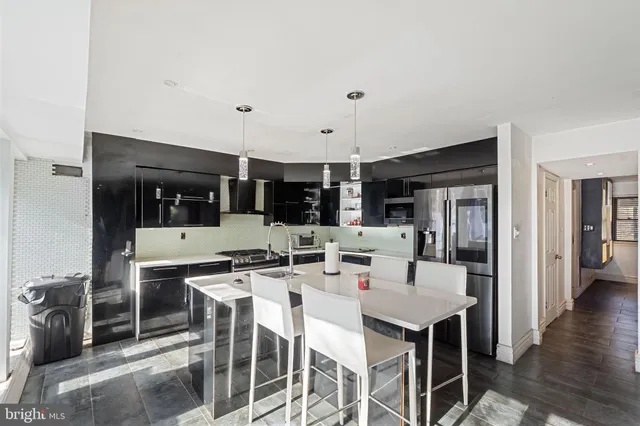 a kitchen with a dining table chairs and white cabinets