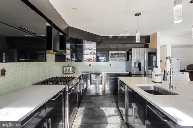 a kitchen with stainless steel appliances kitchen island granite countertop a sink a stove and a microwave