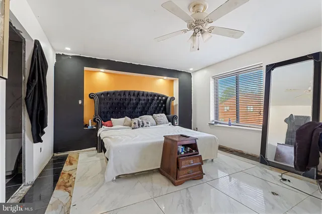 a bedroom with a bed a dresser and a flat screen tv