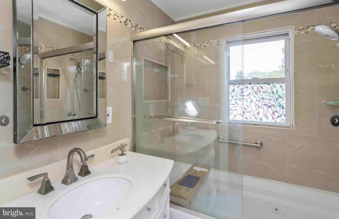 914 Township Line Road Elkins Park, PA 19027 - Photo 18 of 22 a bathroom with a sink mirror and a shower