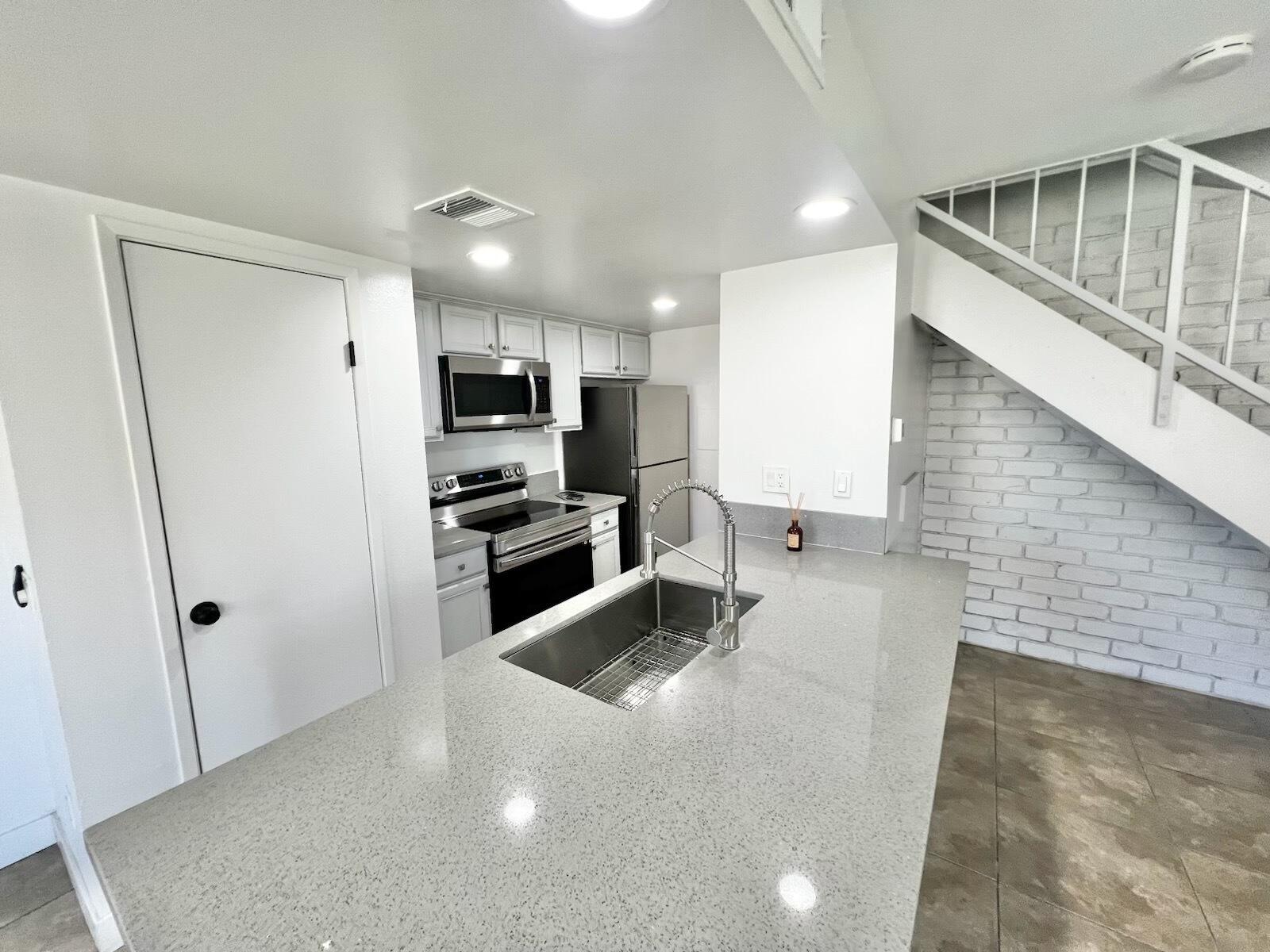 72671 Eagle Road, Unit 3 Palm Desert, CA 92260 - Photo 11 of 25 a kitchen with stainless steel appliances a refrigerator and a stove top oven