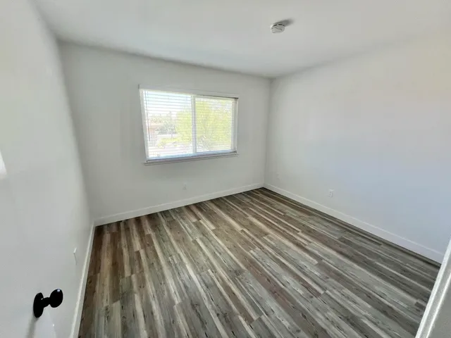 a view of a room with wooden floor and window