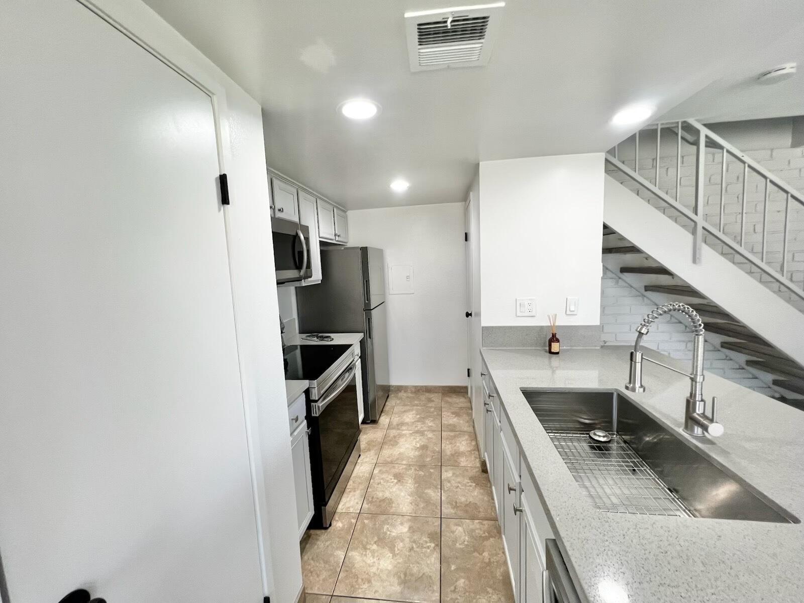 72671 Eagle Road, Unit 3 Palm Desert, CA 92260 - Photo 10 of 25 a kitchen with a sink a counter top space stainless steel appliances and cabinets