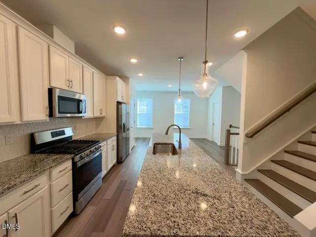 a view of a big room with wooden floor a ceiling fan and windows