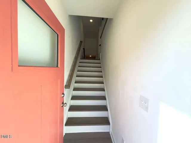 a large kitchen with stainless steel appliances sink refrigerator and wooden floor