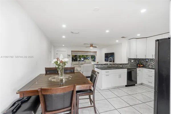 a kitchen with a dining table chairs stainless steel appliances and cabinets