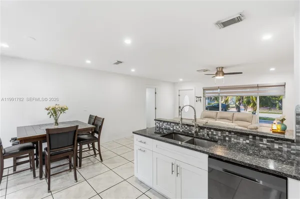 a kitchen with granite countertop a table and chairs in it