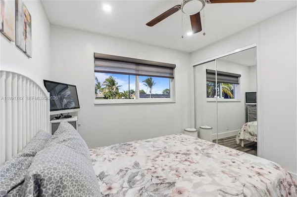 a bedroom that has a bed and a chair with the wooden floor