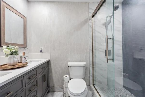 a bathroom with a granite countertop sink toilet and shower