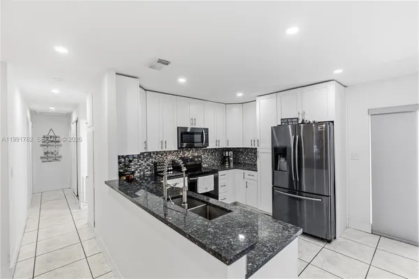 a kitchen with stainless steel appliances granite countertop a refrigerator and a stove