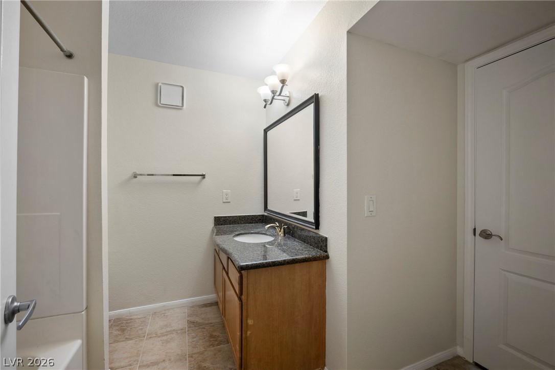 3145 East Flamingo Road, Unit 1055 Las Vegas, NV 89121 - Photo 22 of 40 Functional bathroom features a practical vanity with granite counters and a clean shower stall.