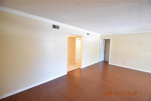 a view of an empty room with wooden floor