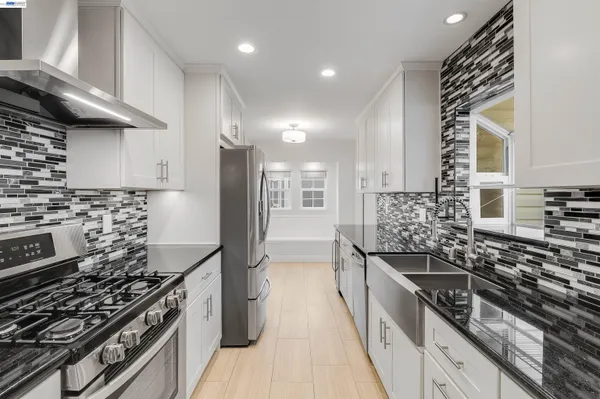 a kitchen with stainless steel appliances granite countertop a stove and a sink
