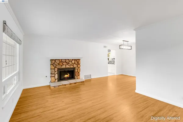 a view of empty room with a fireplace and wooden floor