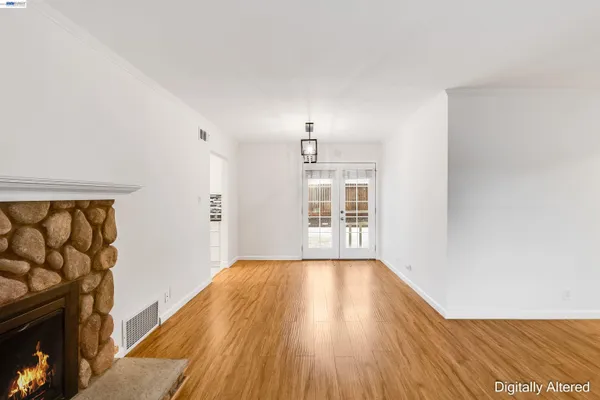 a view of a livingroom with wooden floor and a fireplace