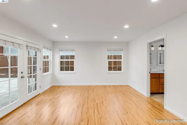 a view of empty room with wooden floor and windows