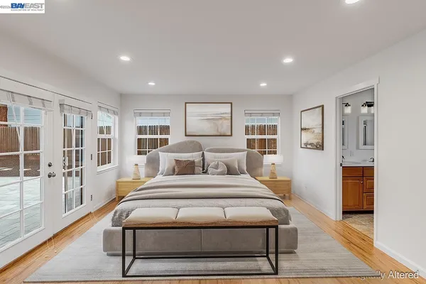a bedroom with a large bed and a wooden floor