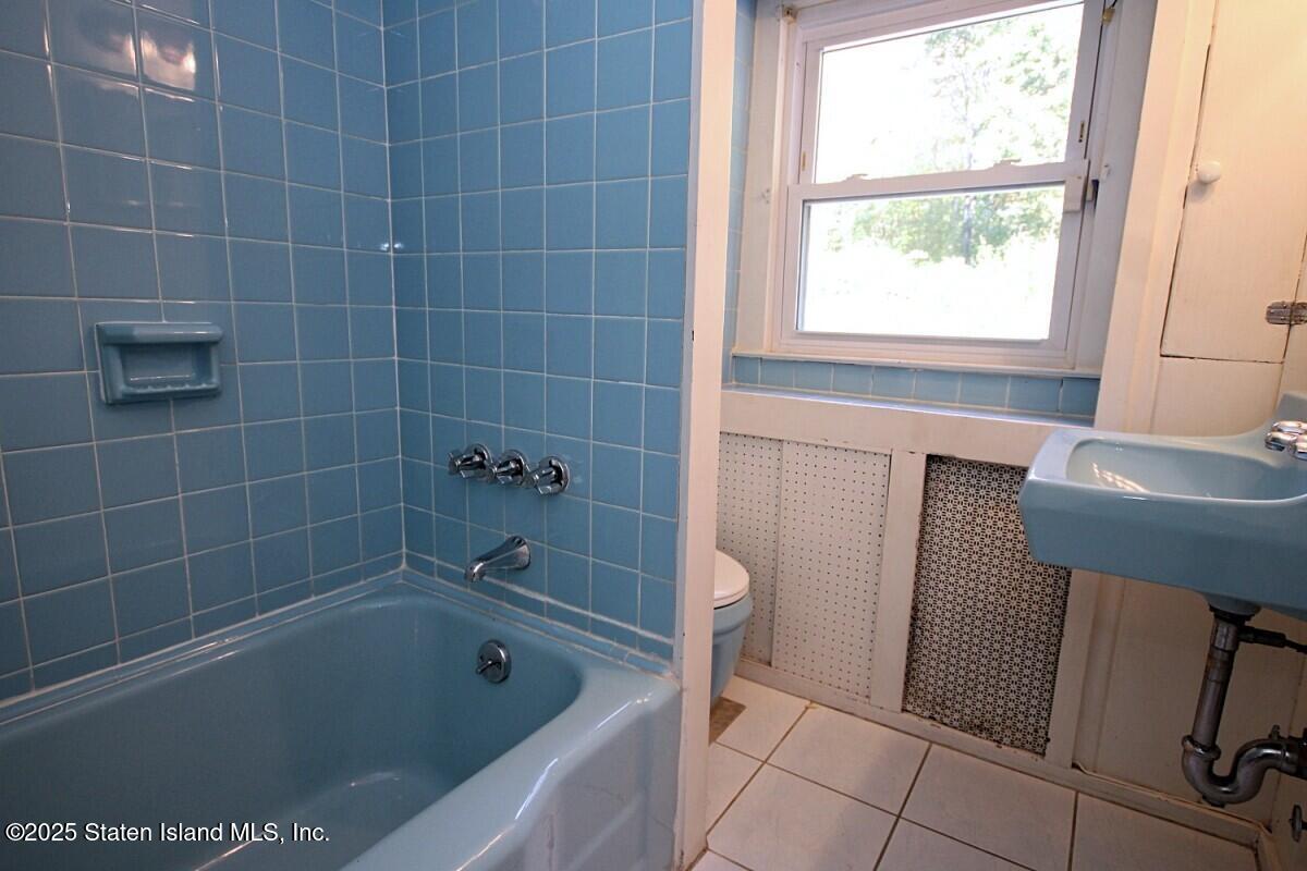 443 Edinboro Road Staten Island, NY 10306 - Photo 22 of 33 a bathroom with a tub a toilet a sink and a shower