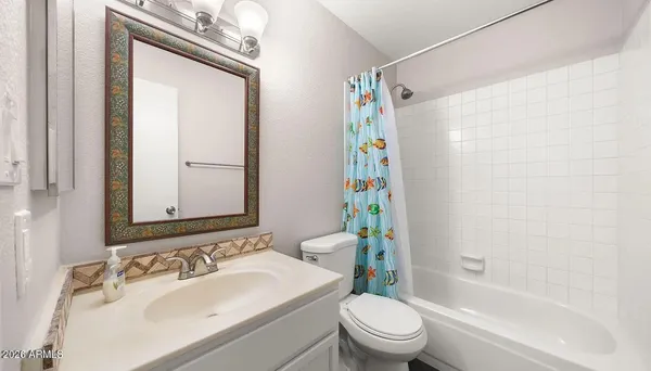 an empty room with white walls and ceiling fan