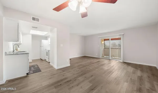 a view of a room with wooden floor and ceiling fan