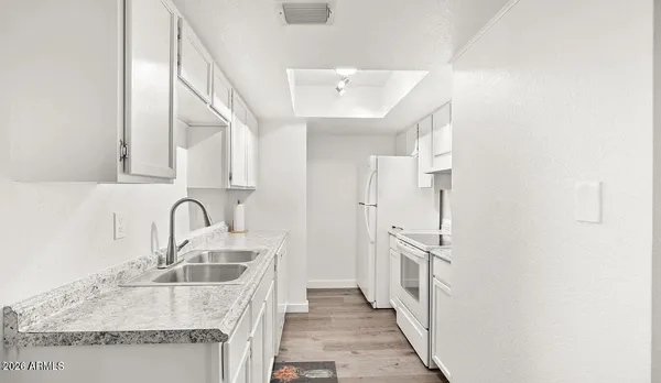 a kitchen with granite countertop a sink a counter space and cabinets