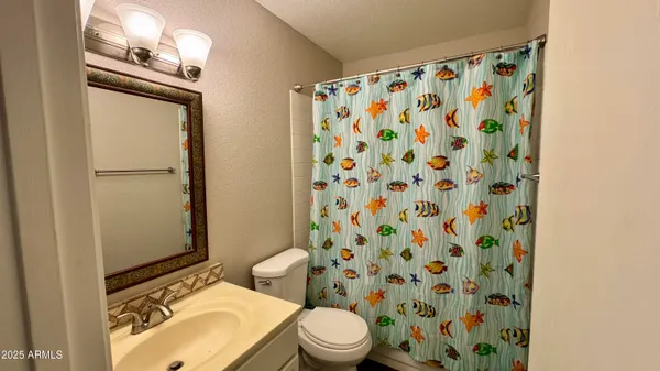 an empty room with a ceiling fan and carpet