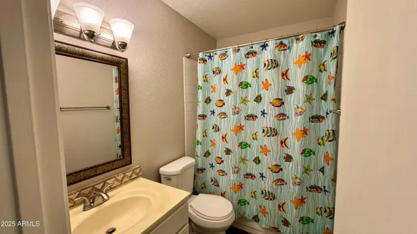 an empty room with a ceiling fan and carpet