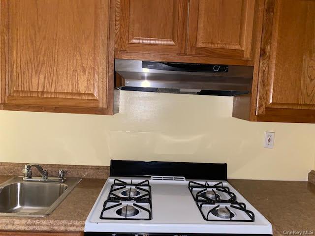 199 Hoover Road, Unit 2F Yonkers, NY 10710 - Photo 11 of 16 Kitchen featuring gas range gas stove, ventilation hood, brown cabinetry, and dark countertops