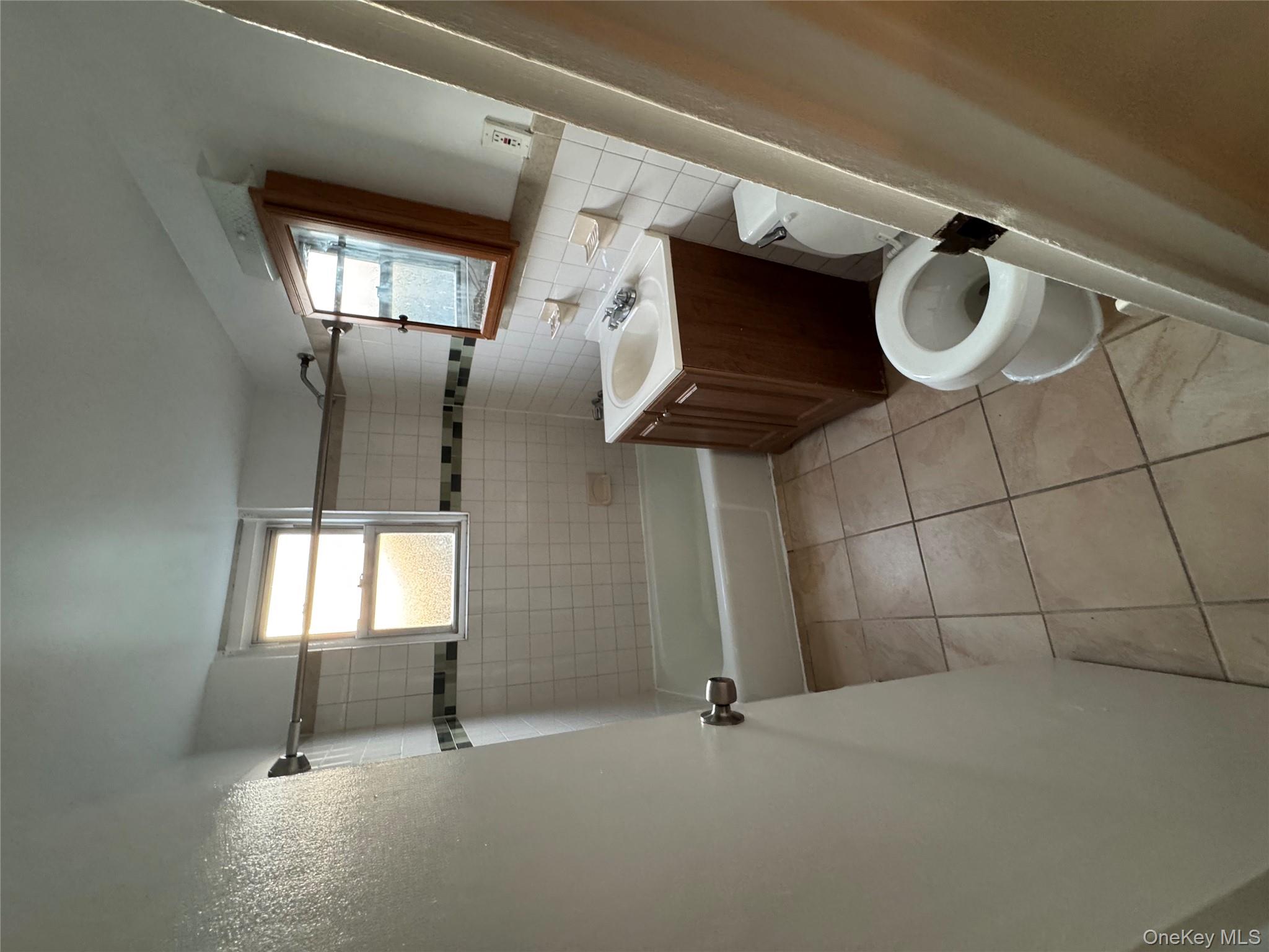 199 Hoover Road, Unit 2F Yonkers, NY 10710 - Photo 9 of 16 Full bath featuring vanity, plenty of natural light, washtub / shower combination, light tile patterned floors, and tile walls