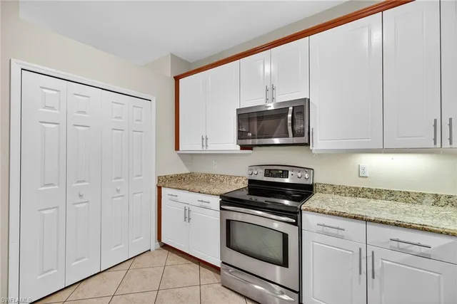 a kitchen with granite countertop white cabinets stainless steel appliances and sink