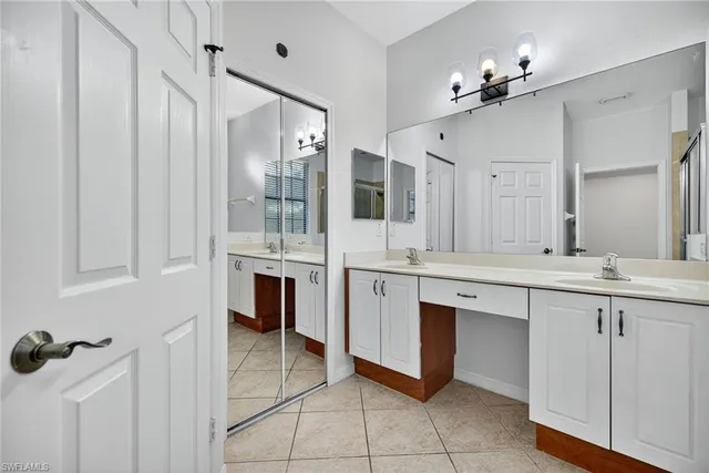a spacious bathroom with a double vanity sink a mirror and a shower