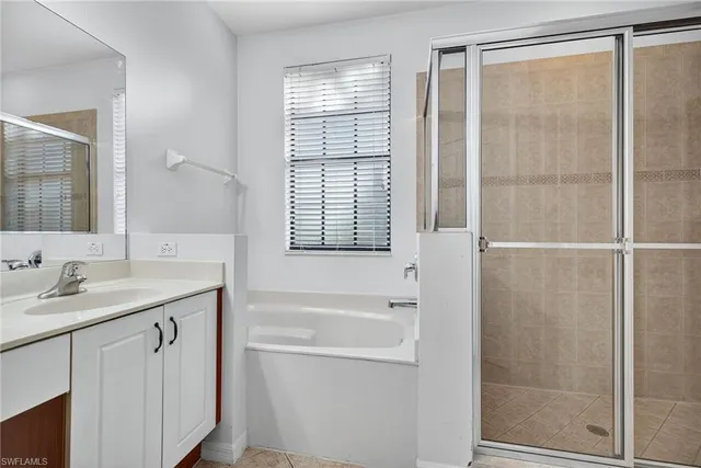 a bathroom with a granite countertop sink a mirror and a shower