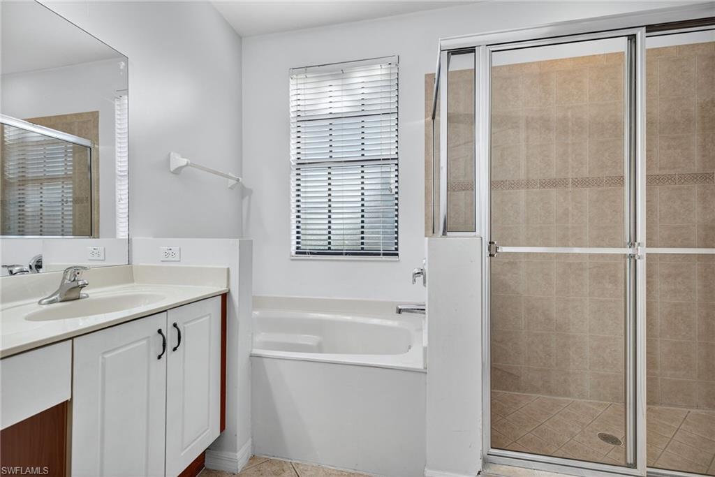 7666 Bristol Circle Naples, FL 34120 - Photo 10 of 19 a bathroom with a granite countertop sink a mirror and a shower