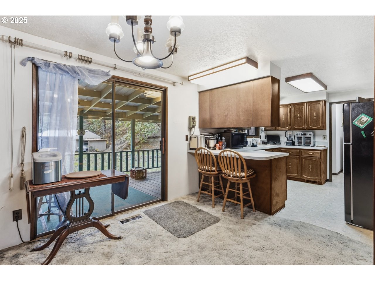 2100 Boyer Road Riddle, OR 97469 - Photo 7 of 33 a open kitchen with stainless steel appliances kitchen island granite countertop a table chairs and a refrigerator