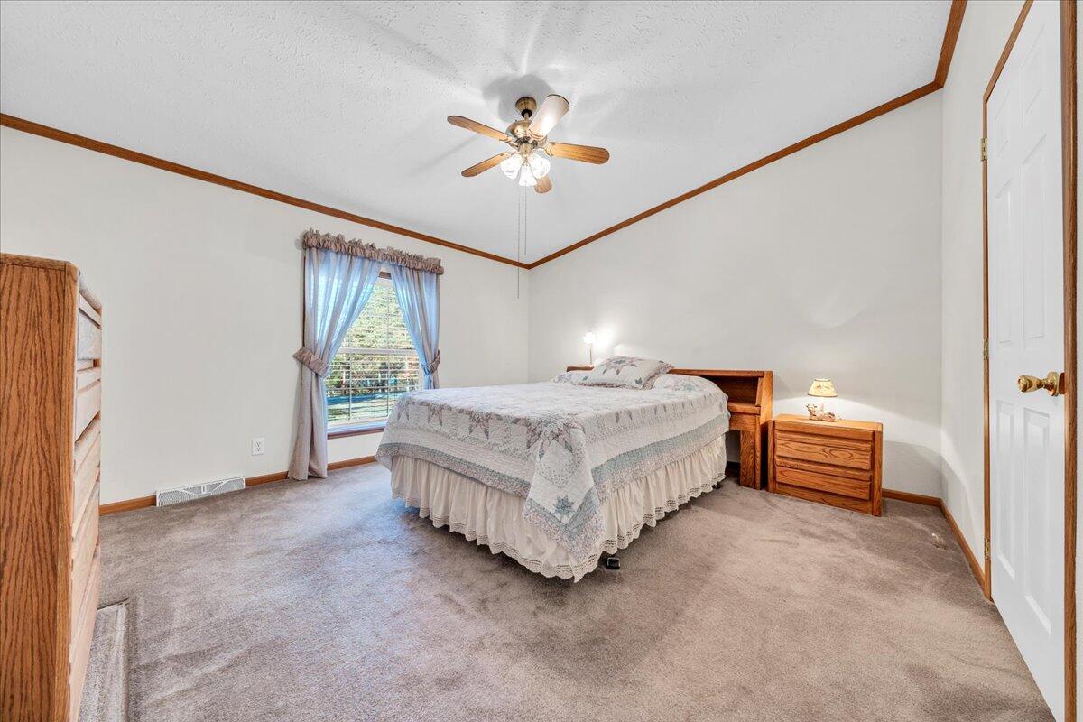 240 Highland Lake Road Union Hall, VA 24176 - Photo 20 of 56 a spacious bedroom with a bed and a chandelier